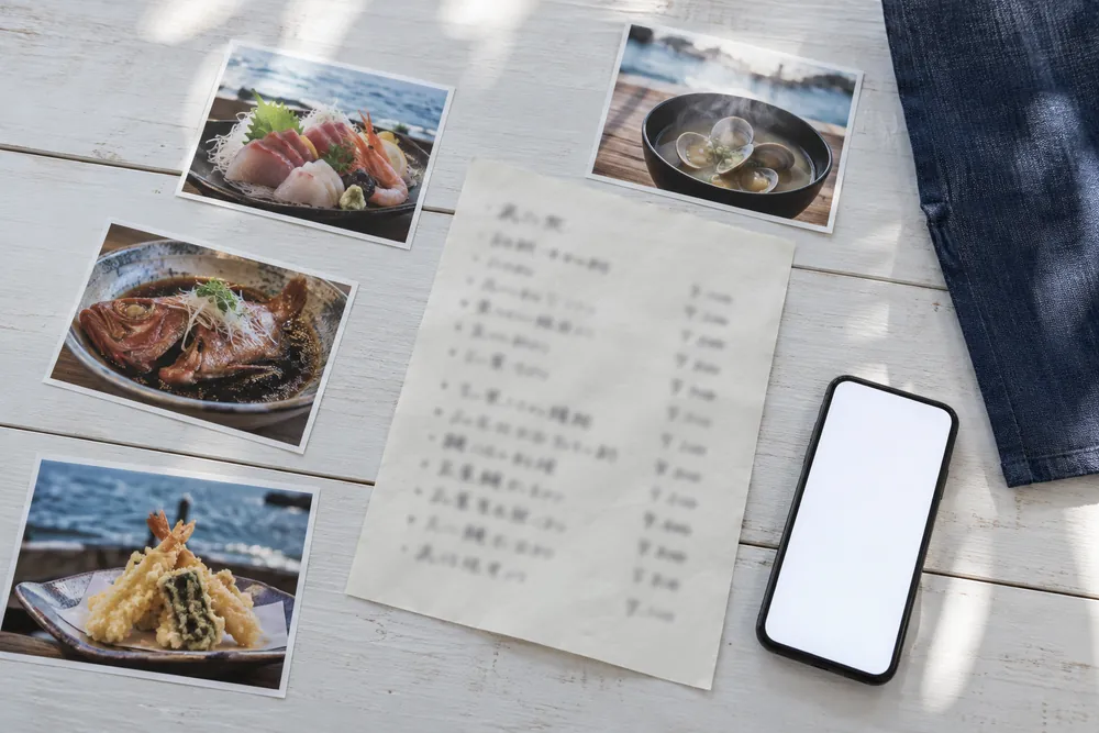 引き継ぐお品書き、料理の写真、スマホを机に並べた様子